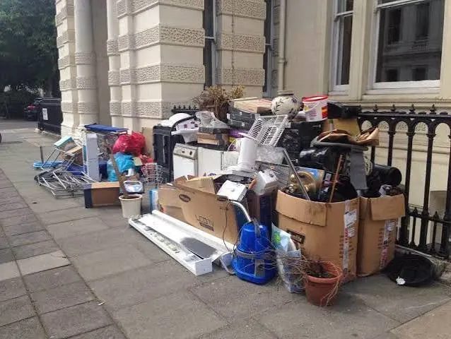 Boxes, appliances and debris piled on a sidewalk outside a business